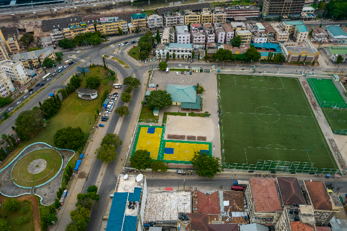 An aerial view of a modern school campus with green fields and clean buildings