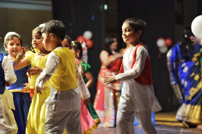 Students performing a choreographed dance in a school studio.