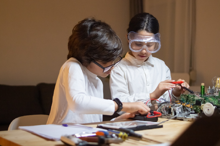 Middle school students working together to build a functional circuit inside the physics lab at VPLS Seoni